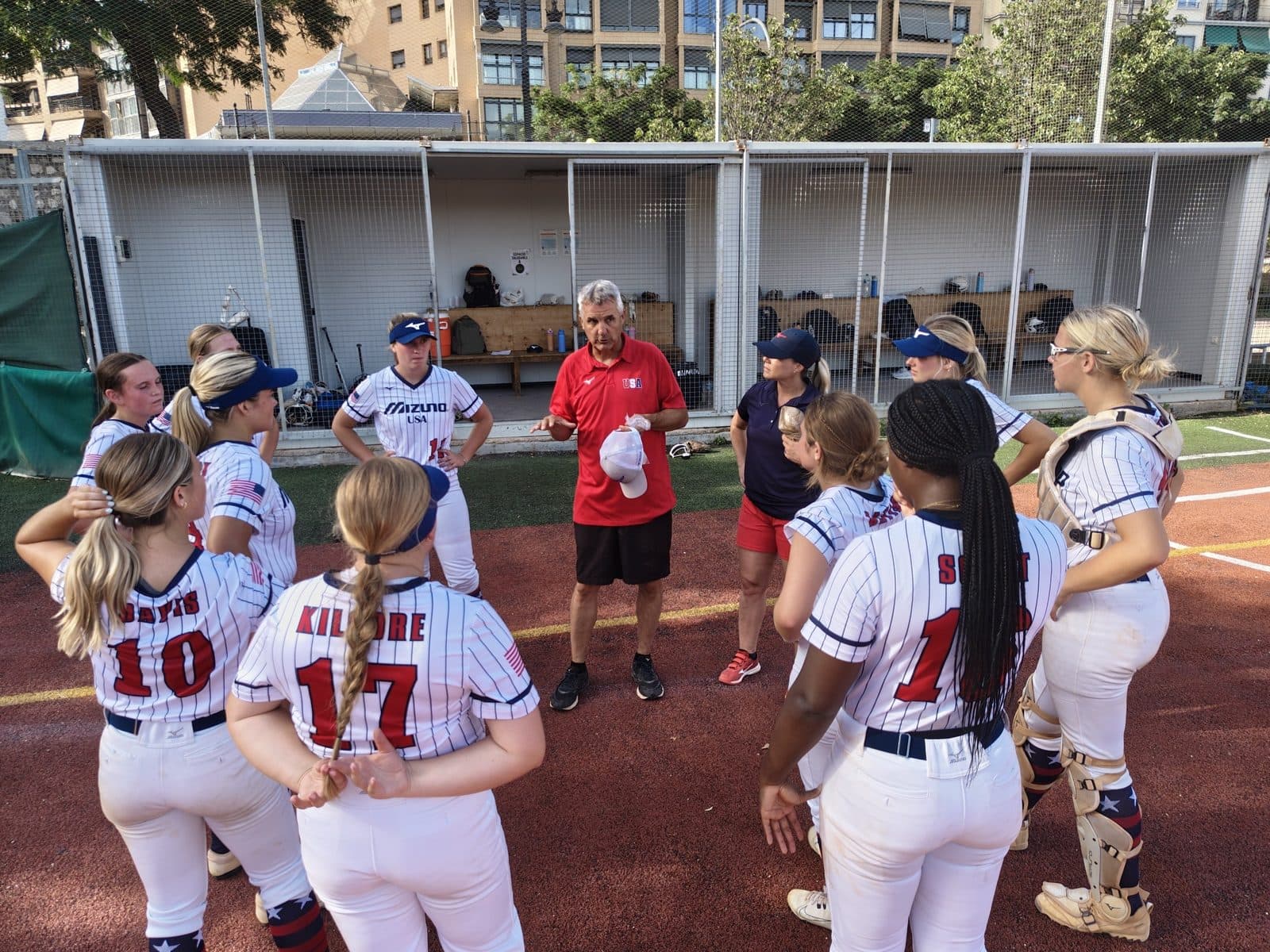 Softball players celebrating together after a game on their tour of Spain