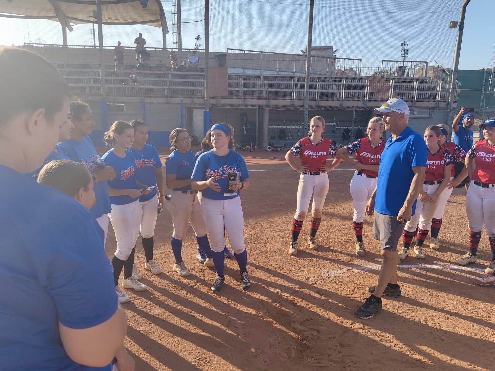 US softball team huddled together before a game against a Spanish club